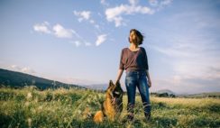 Girl-Standing-In-A-Field-With-Her-German-Shepherd-Dog